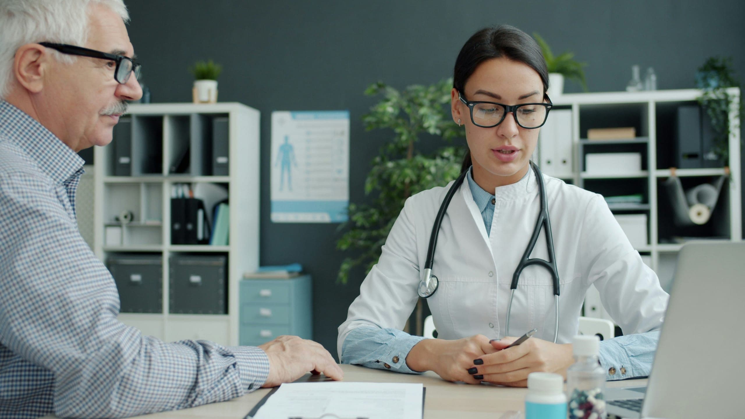 A doctor consulting with an elderly patient in an office